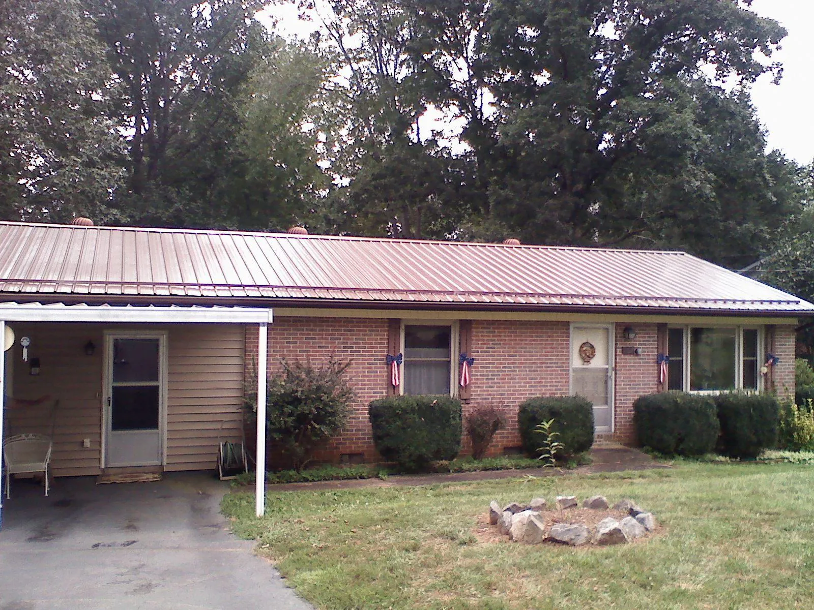 Bronze metal roof and carport on a brick ranch home — Roof Repair work by our crew in Green Springs